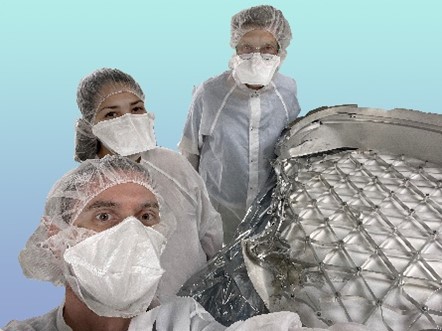 Selfie of Curtis Calva, Carla Gonzalez and Judy Allton examining Genesis science canister hardware